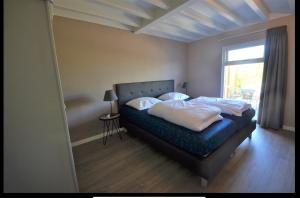 Schlafzimmer mit einem Bett und einem Fenster in der Unterkunft Kustverhuur, Park Schoneveld, Zeester 25 in Breskens