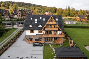 dom z samochodem zaparkowanym przed nim w obiekcie Apartamenty Franka Zakopane w mieście Kościelisko