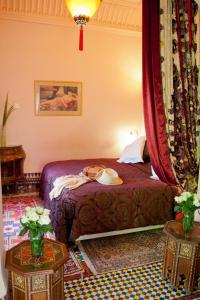 a bedroom with a bed and two end tables at Dar Ayniwen Garden Hotel & Bird Zoo in Marrakesh