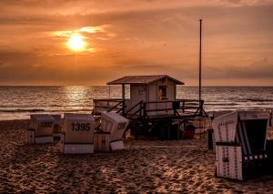 a lifeguard station on the beach at sunset at Wohnung West in Westerland +2 photos