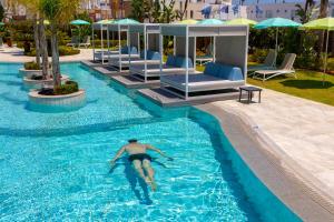 a man in a swimming pool at a hotel at Faros Hotel Ayia Napa in Ayia Napa