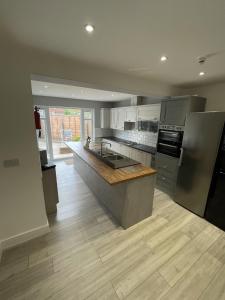 a kitchen with stainless steel appliances and a wooden floor at Cranmore Guest House in Solihull