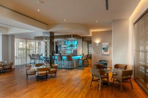 a lobby with tables and chairs and a bar at Faros Hotel Ayia Napa in Ayia Napa
