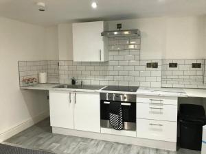 a white kitchen with a stove and a sink at CLIFTON Apartments in Liverpool