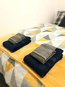 a bed with blue blankets and towels on it at CLIFTON Apartments in Liverpool