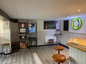 a bar with two slot machines and some stools at The New Wheel Inn in Lymington