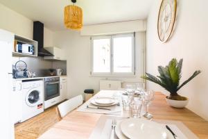 a kitchen and dining room with a table and a clock on the wall at Élégant - Le RemarKable - Parking in Saverne