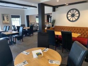 a restaurant with tables and chairs and a couch at The New Wheel Inn in Lymington