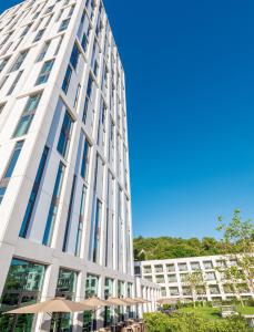 a tall white building with glass windows at Hotel Stadt Lörrach in Lörrach