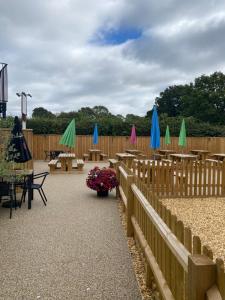 a patio with tables and umbrellas on a fence at The New Wheel Inn in Lymington