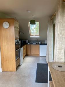 a kitchen with wooden cabinets and a clock on the wall at Scarr View 1st floor Apartment A98W710 in Wicklow