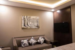 Zimmer mit Sofa und Wandgemälde in der Unterkunft مستقر للشقق الفندقية - النقرة in Ha'il