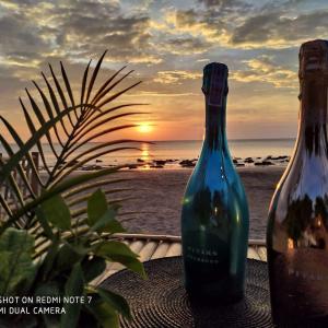two bottles of wine sitting on a table near the beach at The Lazy Lodge in Ko Lanta