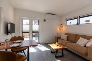 ein Wohnzimmer mit einem Sofa und einem Tisch in der Unterkunft At Sea Zoutelande - Nieuwstraat 15a in Zoutelande