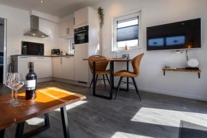 a kitchen and living room with a table with a bottle of wine at At Sea Zoutelande in Zoutelande