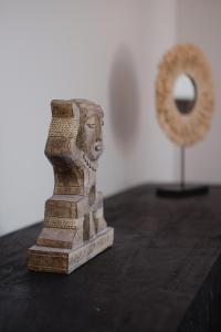 a statue of a lion on a table next to a mirror at Hôtel-Restaurant Villa Métis in Les Herbiers