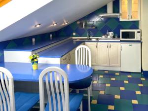 una cocina azul con mesa y sillas azules en Penthouse Apartment in Hotel Eney, en Leópolis