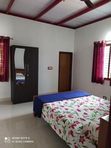 a bedroom with a bed and a mirror at GARDEN VILLA (Home Stay) in Dharmastala