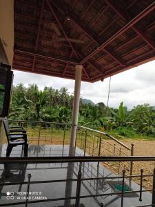 a view from the porch of a house with a chair at GARDEN VILLA (Home Stay) in Dharmastala