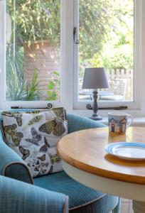 布里德波特的住宿－Bridport Garden Suite，客房设有桌子、椅子和窗户。