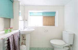 a bathroom with a toilet and a sink at Bridport Garden Suite in Bridport