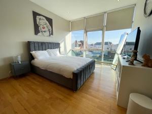 1 dormitorio con cama y ventana grande en City Centre 2-Bed Apartment Parking Jacuzzi Bath, en Glasgow