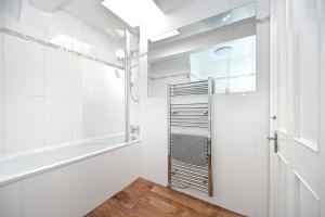 a white bathroom with a tub and a shower at Soho, Piccadilly & Chinatown - Two Bedroom & Two Double Beds Apartment in London