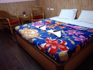 łóżko w pokoju z kolorowym kocem w obiekcie RPM Residency w mieście Kodaikānāl