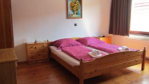 ein Schlafzimmer mit einem Holzbett mit zwei ausgestopften Tieren in der Unterkunft Grüner Baum in Neckargerach