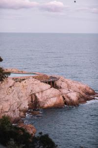a pier on the edge of a cliff in the ocean at BYPILLOW Cap Sa Sal in Begur