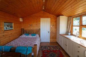 a bedroom with a bed in a wooden cabin at Maid Marian's Lodge, Nottinghamshire in East Bridgford