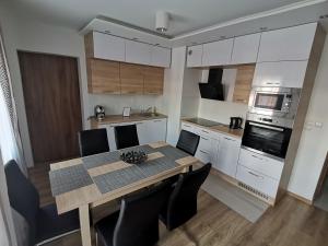 eine Küche mit einem Tisch und Stühlen in der Unterkunft Apartament Dmowskiego - Kępa Mieszczańska in Breslau