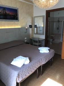 a bedroom with a bed with two towels on it at Hotel Posta in Rota d'Imagna