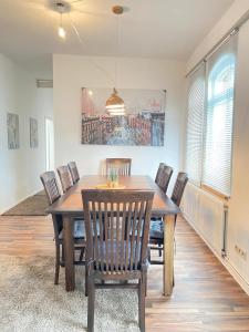 a dining room with a wooden table and chairs at Ganze Citywohnung 4 Schlafzimmer in Hannover