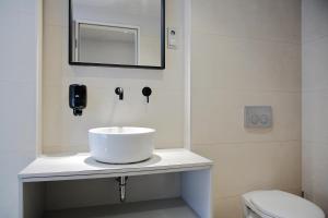 ein Badezimmer mit einem weißen Waschbecken und einem Spiegel in der Unterkunft Maverick Urban Lodge in Budapest