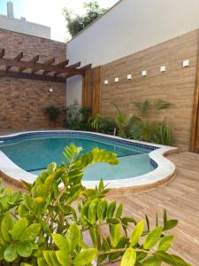a swimming pool in a backyard with a wooden deck at Hotel Portal do Descobrimento in Porto Seguro