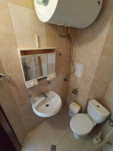 a small bathroom with a toilet and a sink at Sunny Sands Studios in Burgas City