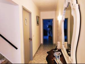 a hallway with a mirror and a table and a hallway with a room at 3 bedrooms house with furnished terrace and wifi at Ponta Delgada in Ponta Delgada
