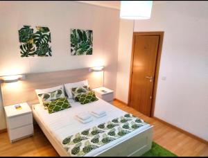 a bedroom with a white bed with green pillows at 3 bedrooms house with furnished terrace and wifi at Ponta Delgada in Ponta Delgada