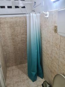 La salle de bains est pourvue d'une douche avec un rideau de douche bleu. dans l'établissement BeB Hotel, à Macapá