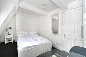 biała sypialnia z łóżkiem i oknem w obiekcie Soho, Piccadilly & Chinatown - Two Bedroom & Two Double Beds Apartment w Londynie