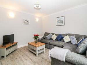 a living room with a couch and a tv at Siena Cottage, 41a Kents Lane in Torquay