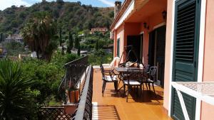 balkon ze stołem i krzesłami w domu w obiekcie Villa Carmelas w Taominie