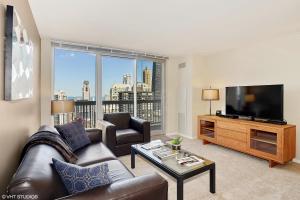 sala de estar con sofá y TV de pantalla plana en The Penthouse at Grand Plaza en Chicago