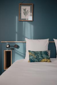 um quarto com uma cama com uma parede azul em Hôtel-Restaurant Villa Métis em Les Herbiers