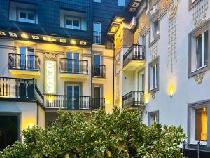 a building with balconies and a tree in front of it at Eney Boutique Hotel in Lviv