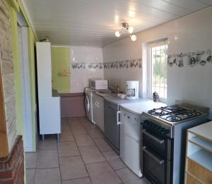 una cucina con piano cottura e lavastoviglie di gîte le voyageur a Tours-en-Vimeu