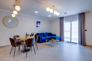 a living room with a blue couch and a table at Art Deco Luxury Apartment, Central Location in Sliema