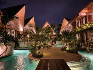 a resort with a swimming pool at night at Beyond Bayou in Seminyak
