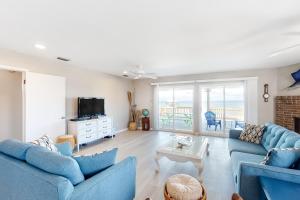 een woonkamer met twee blauwe banken en een televisie bij Little Grand Hotel in Dauphin Island